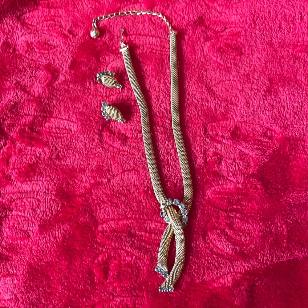 Vintage looking gold necklace and clip earrings. Smoky rhinestone setting.
